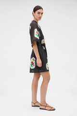 Profile view of model wearing the Oroton Folk Doilie Print Smock Dress in Black and 100% cotton fabric for Women .