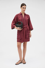 Profile view of model wearing the Oroton Handkerchief Tunic Dress in Burgundy and 100% mid-weight linen fabric for Women .