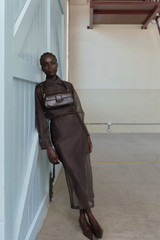 Profile view of model wearing the Oroton Organdy Pencil Skirt in Chocolate and 100% silk fabric for Women .