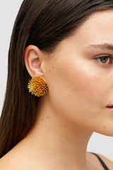 Profile view of model wearing the Oroton Urchin Earrings in Worn Gold and Premium brass material for Women .