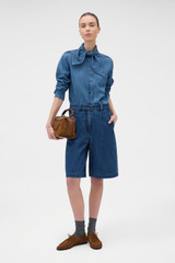 Profile view of model wearing the Oroton  Denim Bermuda in DENIM and 90% cotton and 10% polyester blend fabric for Women .