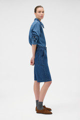 Profile view of model wearing the Oroton  Denim Bermuda in DENIM and 90% cotton and 10% polyester blend fabric for Women .