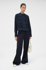 Profile view of model wearing the Oroton Doilie Detail Top in NORTH SEA and 100% linen fabric for Women .