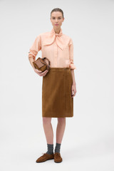 Profile view of model wearing the Oroton Tie Neck Shirt in APPLE PEACH and 100% cotton poplin fabric for Women .
