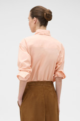 Profile view of model wearing the Oroton Tie Neck Shirt in APPLE PEACH and 100% cotton poplin fabric for Women . IP:5