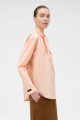 Profile view of model wearing the Oroton Tie Neck Shirt in APPLE PEACH and 100% cotton poplin fabric for Women . IP:4