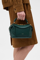 Profile view of model wearing the Oroton Mica Mini Bowler in IVY and Premium pebble leather for Women .
