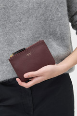 Profile view of model wearing the Oroton Eve Small Pouch in BURGUNDY and Premium pebble leather for Women .