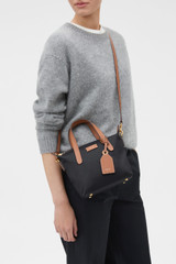 Profile view of model wearing the Oroton Lilly Nylon Small Crossbody Tote in BLACK/COGNAC and Nylon fabric for Women .