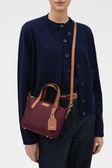 Profile view of model wearing the Oroton Lilly Nylon Small Crossbody Tote in BURGUNDY and Nylon fabric for Women .