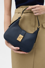 Profile view of model wearing the Oroton Yvonne Baguette in DARK NAVY and Premium pebble leather for Women .
