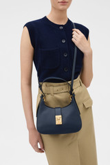 Profile view of model wearing the Oroton Yvonne Baguette in DARK NAVY and Premium pebble leather for Women .