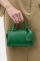 Profile view of model wearing the Oroton Harvey Tiny Barrel in CROCODILE and Premium smooth leather for Women .