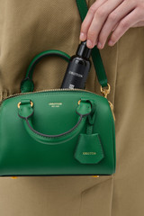Profile view of model wearing the Oroton Harvey Tiny Barrel in CROCODILE and Premium smooth leather for Women .