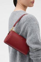 Profile view of model wearing the Oroton Harvey Baguette Crossbody in BERRY and Premium smooth leather for Women .