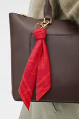 Profile view of model wearing the Oroton Eve Scarf Keyring in DARK RUBY and 100% polyester fabric for Women .