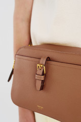 Profile view of model wearing the Oroton Dylan Camera Crossbody in Tan and Premium pebble leather for Women .