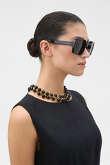 Profile view of model wearing the Oroton Atlas Sunglasses in Black and Acetate material for Women .