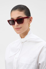 Profile view of model wearing the Oroton  Landry Sunglasses in Cherry and Acetate material for Women .