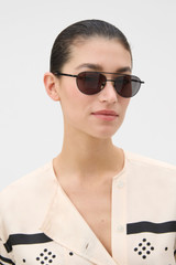 Profile view of model wearing the Oroton Beck Sunglasses in Black and Monel / Acetate material for Women .