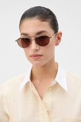 Profile view of model wearing the Oroton Beck Sunglasses in Silver and Monel / Acetate material for Women .