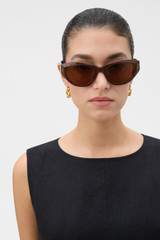 Profile view of model wearing the Oroton Whitely Sunglasses in Chocolate and Acetate material for Women .