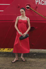 Profile view of model wearing the Oroton Sculptured Bodice Dress in POPPY and 85% polyester and 15% silk blend fabric for Women .