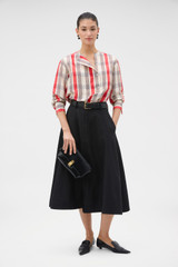 Profile view of model wearing the Oroton Zip Midi Skirt in BLACK and 100% heavyweight linen fabric for Women .