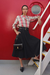 Profile view of model wearing the Oroton Zip Midi Skirt in BLACK and 100% heavyweight linen fabric for Women .