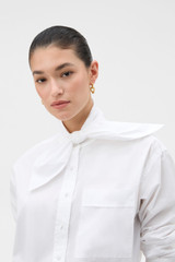 Profile view of model wearing the Oroton Tie Neck Shirt in WHITE and 100% cotton poplin fabric for Women .