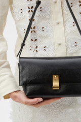 Profile view of model wearing the Oroton Etta Medium Clutch in DARK CHOCOLATE and Premium crackle leather for Women . IP:3