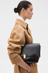 Profile view of model wearing the Oroton Etta Large Clutch in DARK CHOCOLATE and Premium crackle leather for Women .