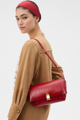 Profile view of model wearing the Oroton Etta Eel Medium Clutch in LAVA and Premium embossed leather for Women . IP:4