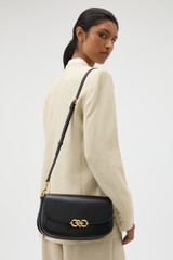 Profile view of model wearing the Oroton Olivia Day Bag in BLACK and Premium crackle leather for Women .