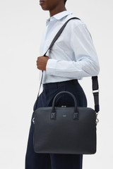Profile view of model wearing the Oroton Larsen Briefcase in NIGHT SKY and Premium pebble leather for Men .