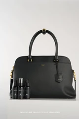 Profile view of model wearing the Oroton Iris Double Zip 14" Tote Bag in Black and Premium pebble leather for Women .