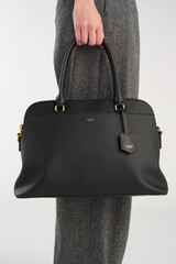 Profile view of model wearing the Oroton Iris Double Zip 14" Tote Bag in Black and Premium pebble leather for Women .