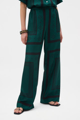 Profile view of model wearing the Oroton SPOT SCARF PRINT TROUSER in HELM GREEN and 100% silk twill fabric for Women .