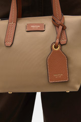 Profile view of model wearing the Oroton Lilly Nylon Small Crossbody Tote in MUSHROOM/COGNAC and Nylon fabric for Women .