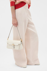 Profile view of model wearing the Oroton Dylan Day Bag in CREAM and Premium pebble leather for Women .