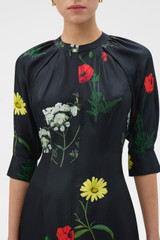 Profile view of model wearing the Oroton Wild Flower Print Dress in BLACK and 100% silk twill fabric for Women .