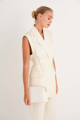 Profile view of model wearing the Oroton Inez Slim Crossbody in Cream and Saffiano Leather for Women .