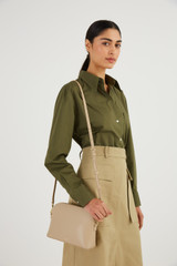Profile view of model wearing the Oroton Inez Slim Crossbody in Fawn and Smooth Saffiano for Women .