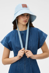 Profile view of model wearing the Oroton Denim Bucket Hat in CHAMBRAY and 100% cotton fabric for Women .