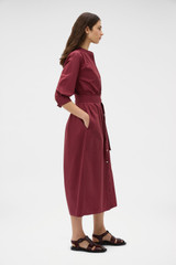 Profile view of model wearing the Oroton Weekend Shirt Dress in Rouge and 100% cotton fabric for Women .