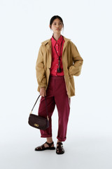 Profile view of model wearing the Oroton Arlo Washed Parka in Cashew and 100% cotton fabric for Women .