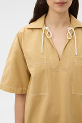 Profile view of model wearing the Oroton Drill Popover Dress in Cashew and 100% cotton fabric for Women .
