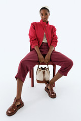 Profile view of model wearing the Oroton Knit Trim Bomber in Cerise and 100% cotton fabric for Women .