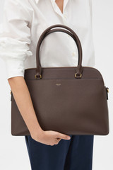 Profile view of model wearing the Oroton Iris Double Zip 14" Tote Bag in Coffee Bean and Premium pebble leather for Women .