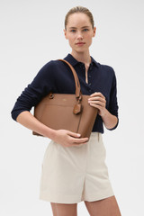 Profile view of model wearing the Oroton Iris Small Tote in Cinnamon and Premium pebble leather for Women .